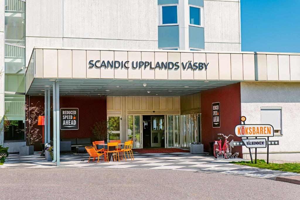 乌普兰斯韦斯比斯堪迪克乌普兰斯韦斯比酒店的前面设有桌椅的建筑