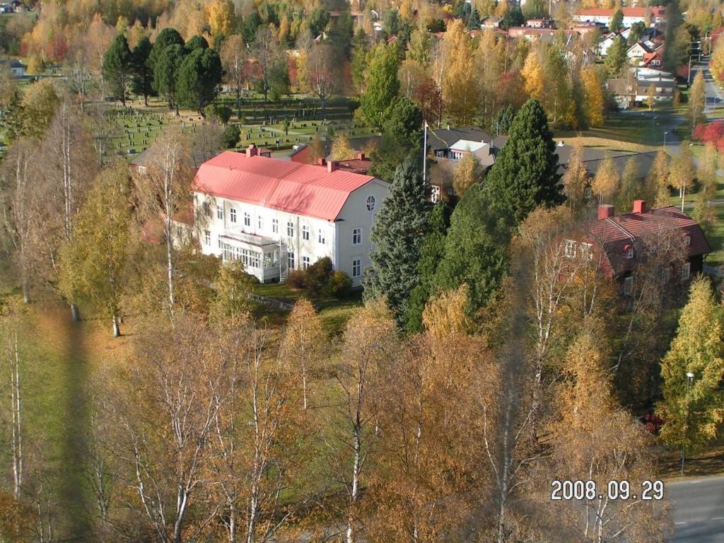 谢莱夫特奥Stiftsgården Konferens & Hotell的山坡上一座白色大房子,有红色屋顶