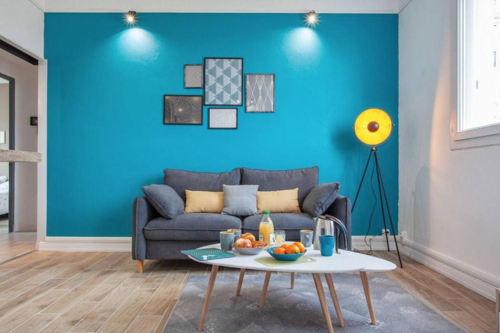 尼姆Atlas - Ovalia的蓝色的客厅配有沙发和桌子
