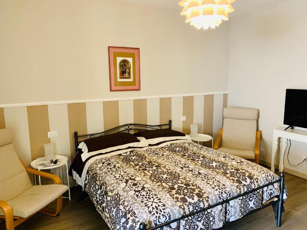 彼得拉桑塔CB House Tuscany 2的一间卧室配有一张床、两把椅子和电视