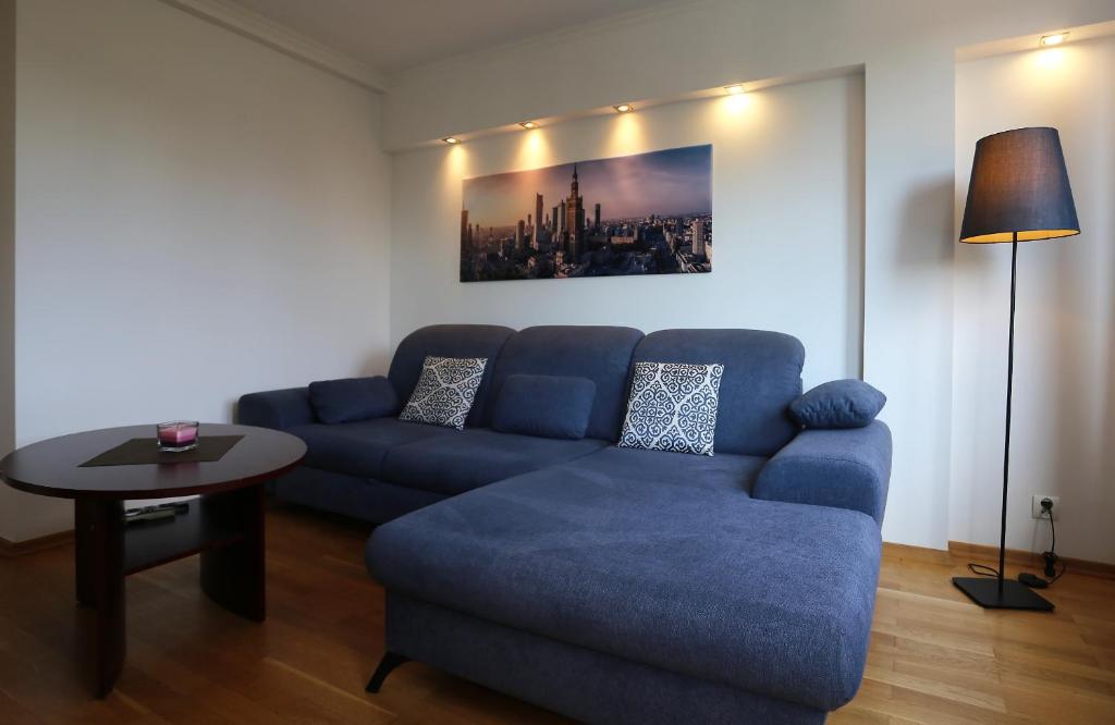 华沙Apartament MGM Karmelicka的客厅配有蓝色的沙发和桌子