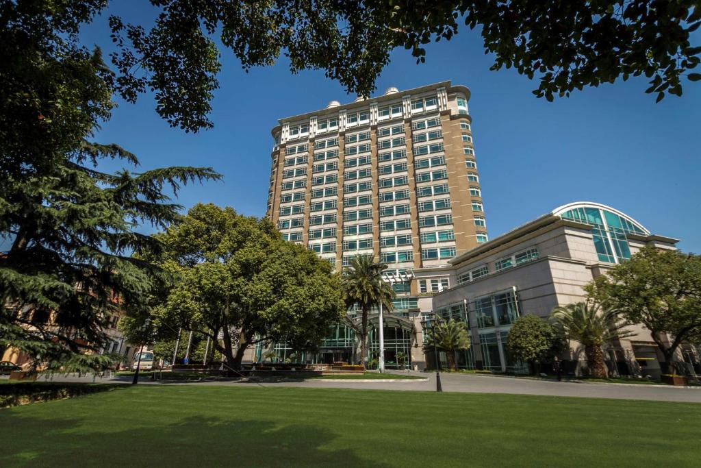 上海上海兴国宾馆丽笙精选的一座高大的建筑,前面有一个公园