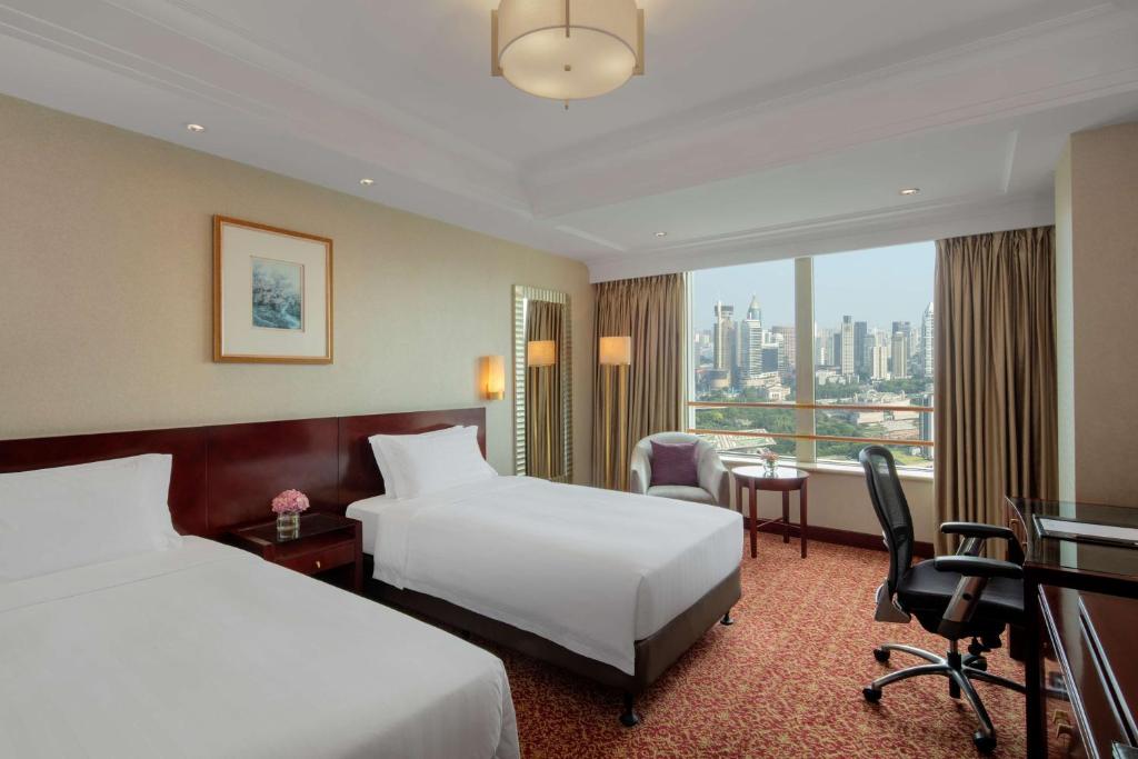上海上海新世界丽笙大酒店的酒店客房配有两张床和一张书桌