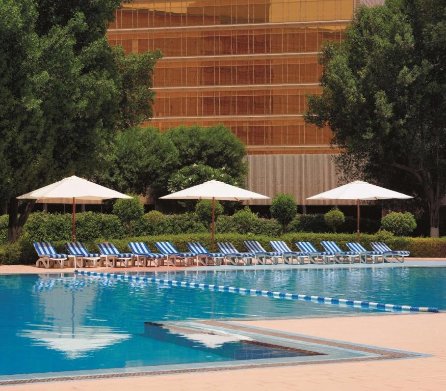 多哈Radisson Blu Hotel, Doha的一个带躺椅和遮阳伞的游泳池