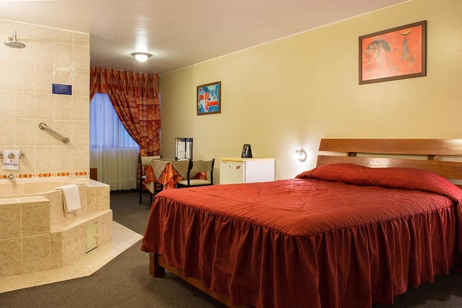 利马Los Mirtos suite & Hotel的一间卧室配有一张床和浴缸