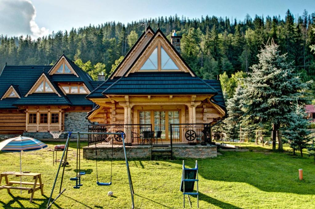 扎科帕内Domek drewniany luxury cottage Dabrowa的小木屋前方设有游乐场