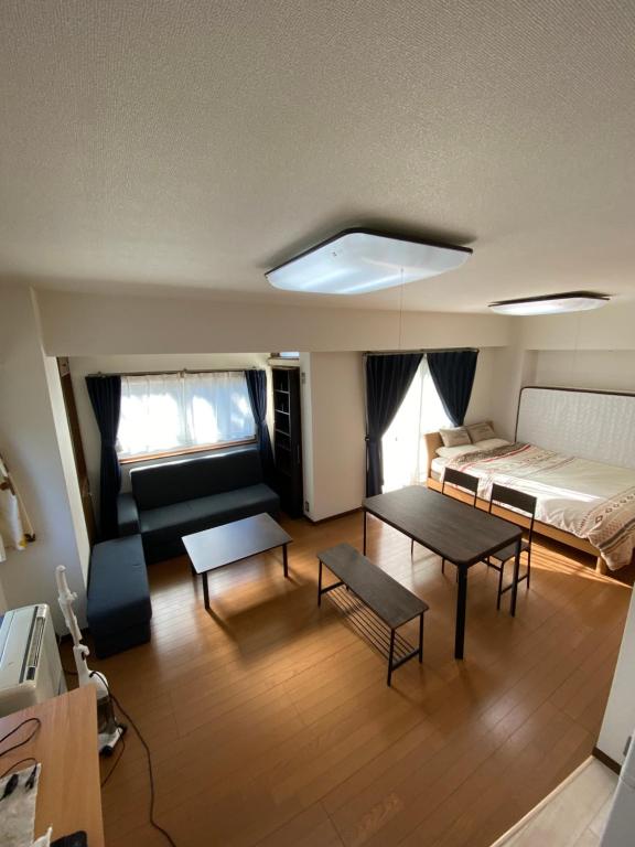 东京G&R House 101的客厅配有床和桌子