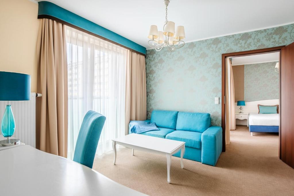 奥普尔Hotel Opole Centrum的一间配备有蓝色沙发和床的客房