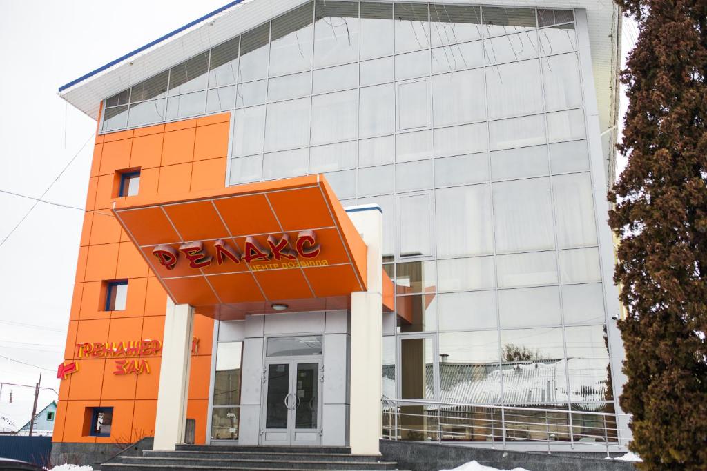 KorostyshivГотель Релакс的一座橙色和白色的建筑,上面有标志