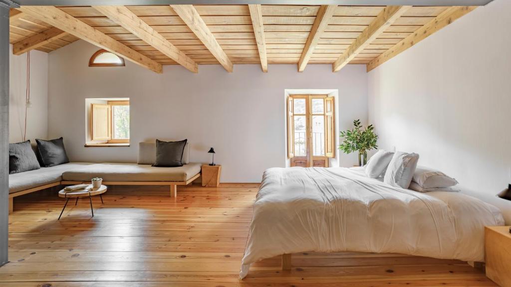 MontelláCal Calsot Casa Rural "Adults Only"的一间卧室配有一张大床和一张沙发