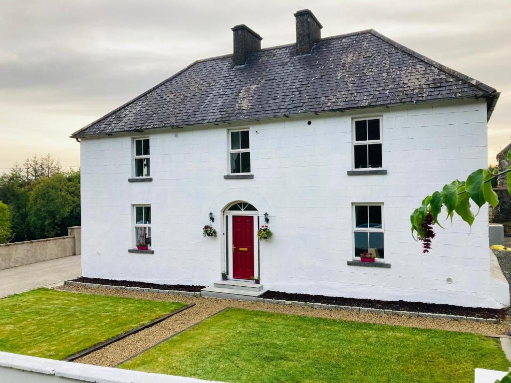 尼纳Entire Farmhouse in Tipperary的一间红色门的白色房子