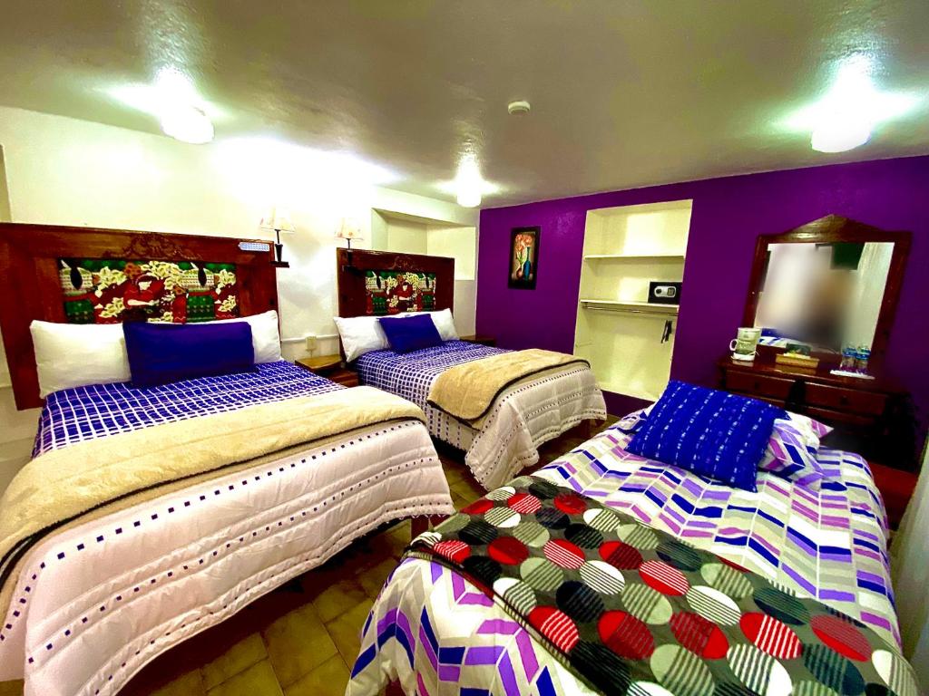 瓜纳华托Hotel Magdalena Colonial的紫色墙壁客房的两张床