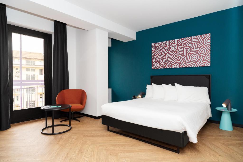 都灵CX Turin Belfiore Student&Explorer Place的一间卧室设有一张大床和蓝色的墙壁