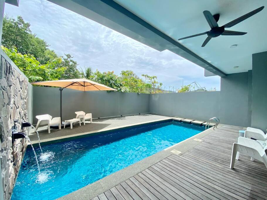 珍南海滩LeGrace Villa Langkawi Private Pool的一个带庭院和遮阳伞的游泳池