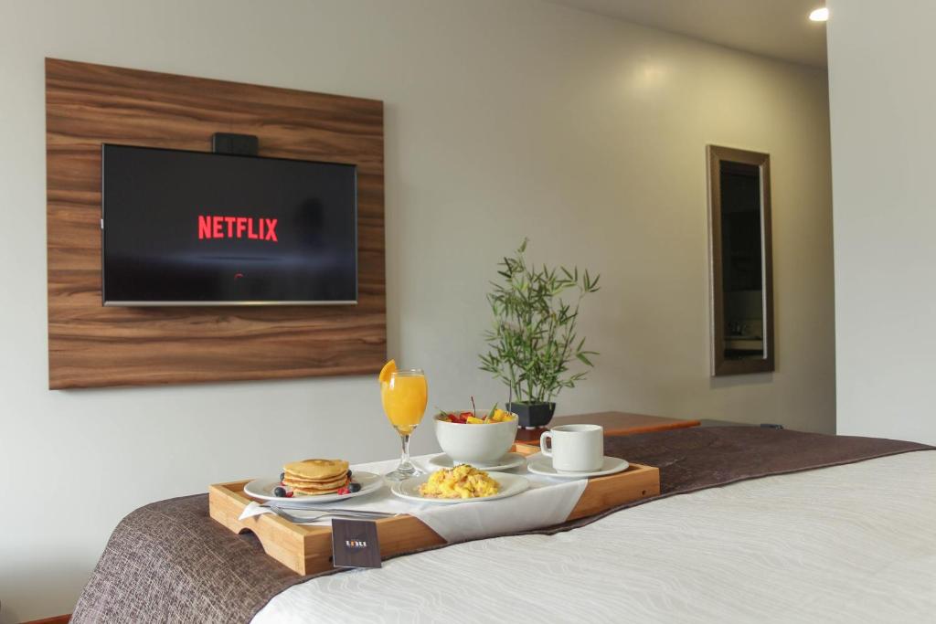 万卡约Hotel Unu的床上的食品托盘,带电视