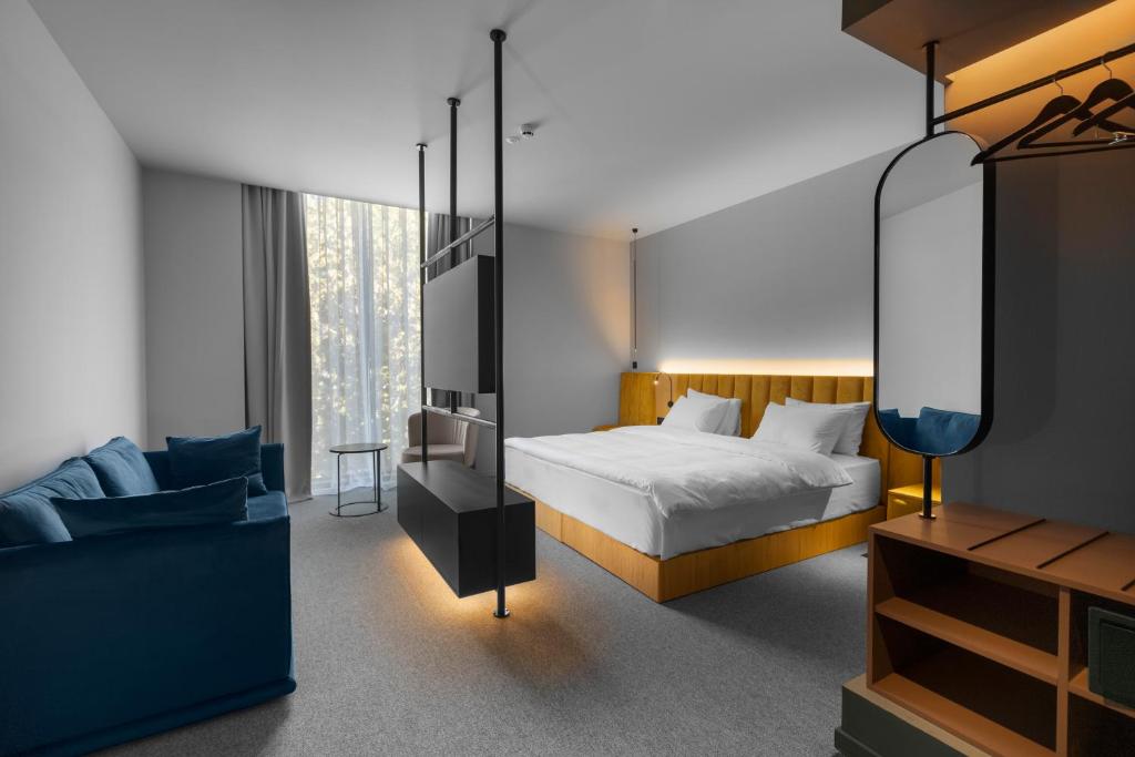 第比利斯Episode Tbilisi的一间卧室配有一张床、一张沙发和一面镜子