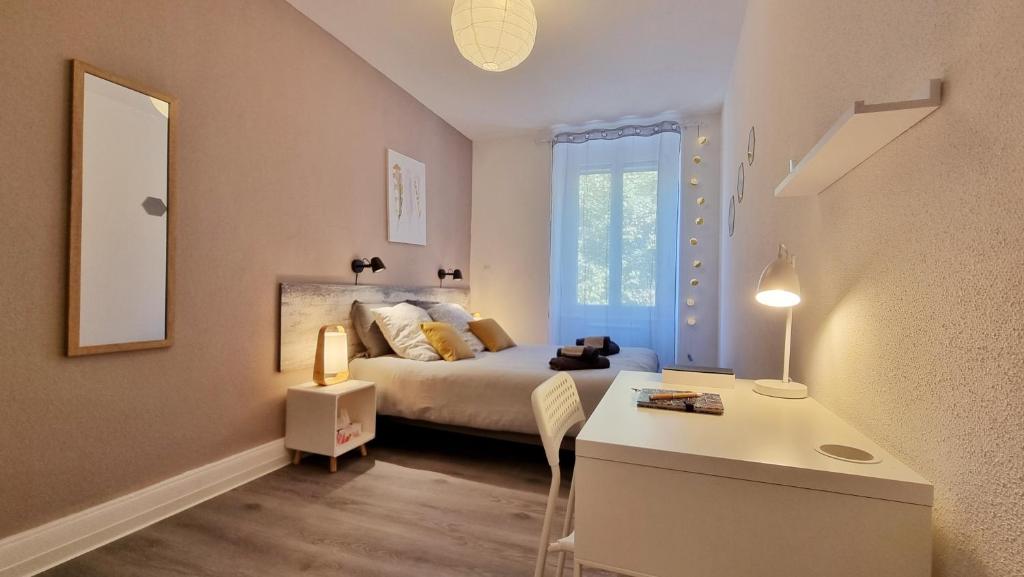 米卢斯Bulles de sommeil - Cozy - RBNB的一间卧室配有一张床、一张书桌和一面镜子