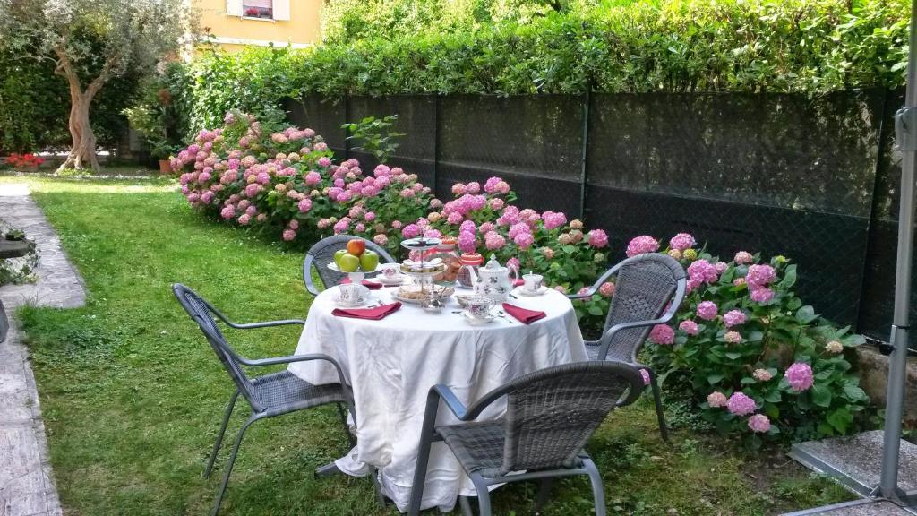 维罗纳阿格利艾塞里住宿加早餐酒店的花园里的桌子,摆放着椅子和鲜花