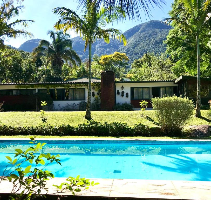 彼得罗波利斯Pinheiros do Rocio的一座房子,后面设有游泳池和山脉