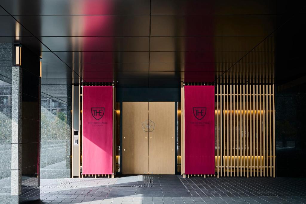 京都The Royal Park Hotel Kyoto Umekoji的建筑物一侧的两扇粉红色门