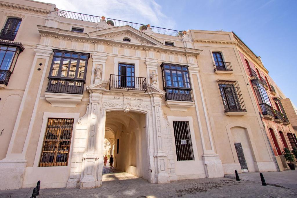 塞维利亚Real Casa de la Moneda Deluxe Apartments的前面有拱门的大建筑