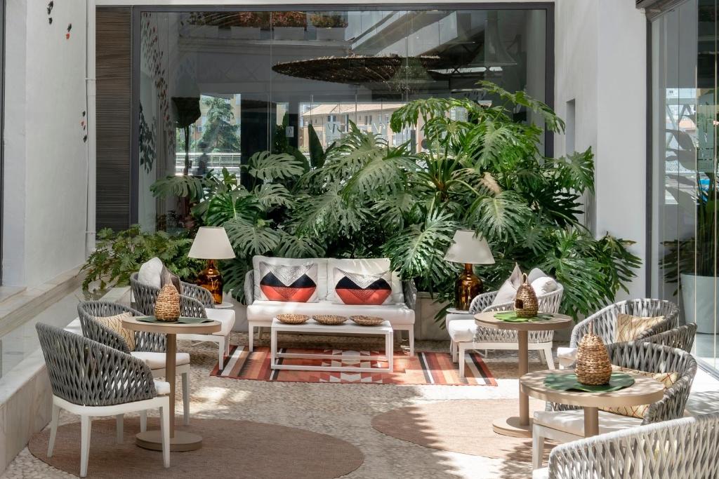 马拉加普桑达帕提欧斯莱克森温齐酒店的庭院配有桌椅和沙发。