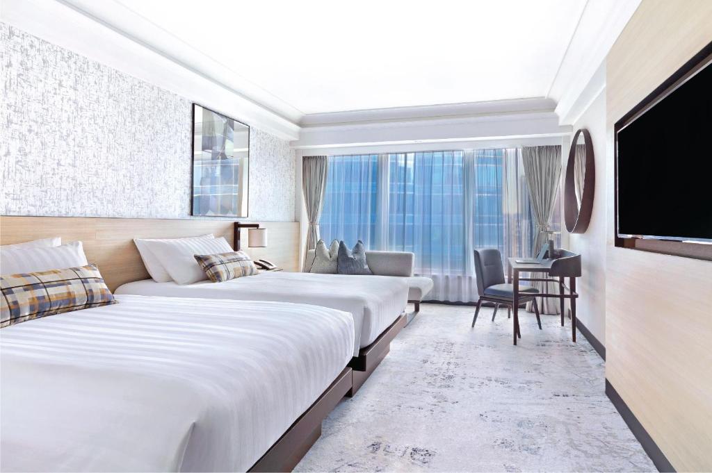 香港九龙海逸君绰酒店的酒店客房设有两张床和一台平面电视。