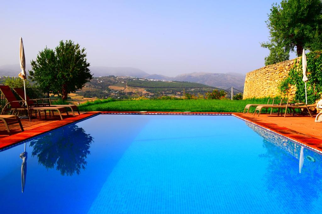 隆达Villa Casa Alta的一个带椅子和树木的大型蓝色游泳池