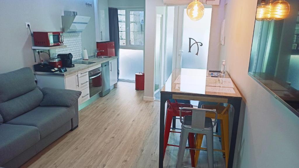 梅里达Alcazaba - Free Parking的厨房以及带沙发和桌子的客厅。