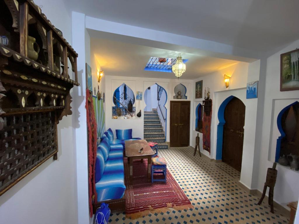 舍夫沙万Dar Essaouyry的客厅设有蓝色的沙发和楼梯。