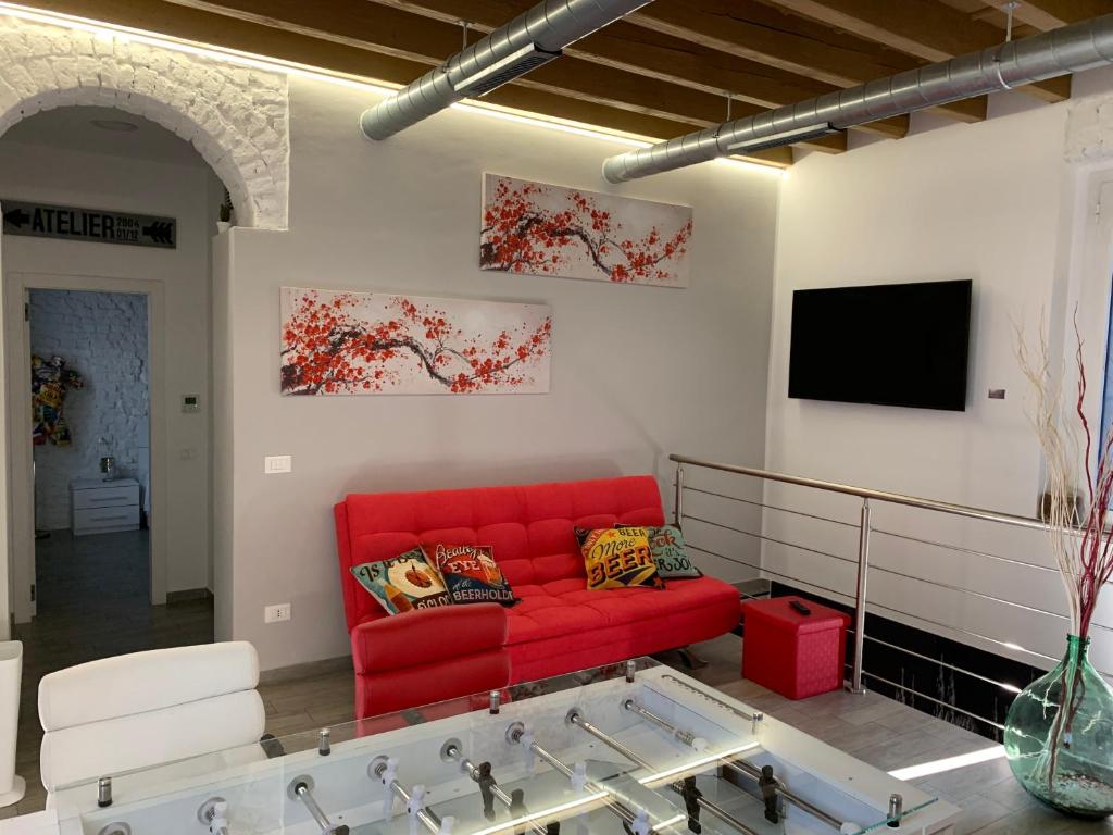 米兰CA FOSCARI Loft & Factory的客厅配有红色沙发和电视