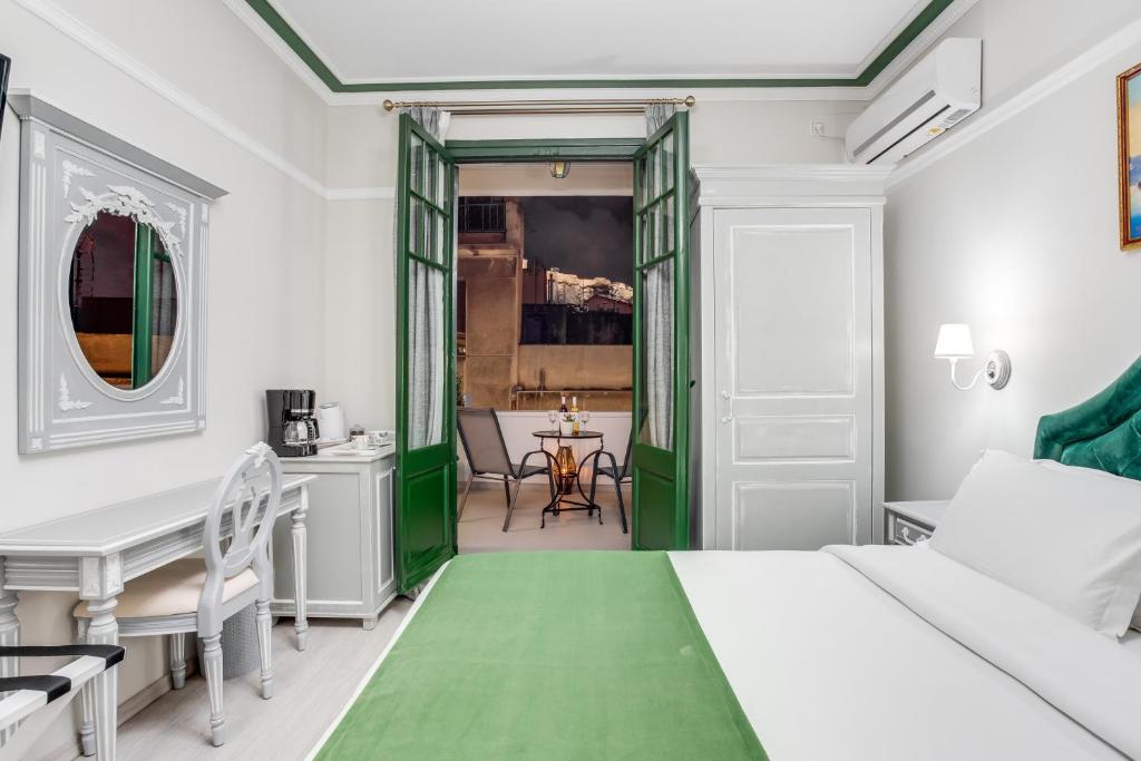 雅典Pandrosos Divine Suites的一间卧室配有一张绿色的床和一张桌子