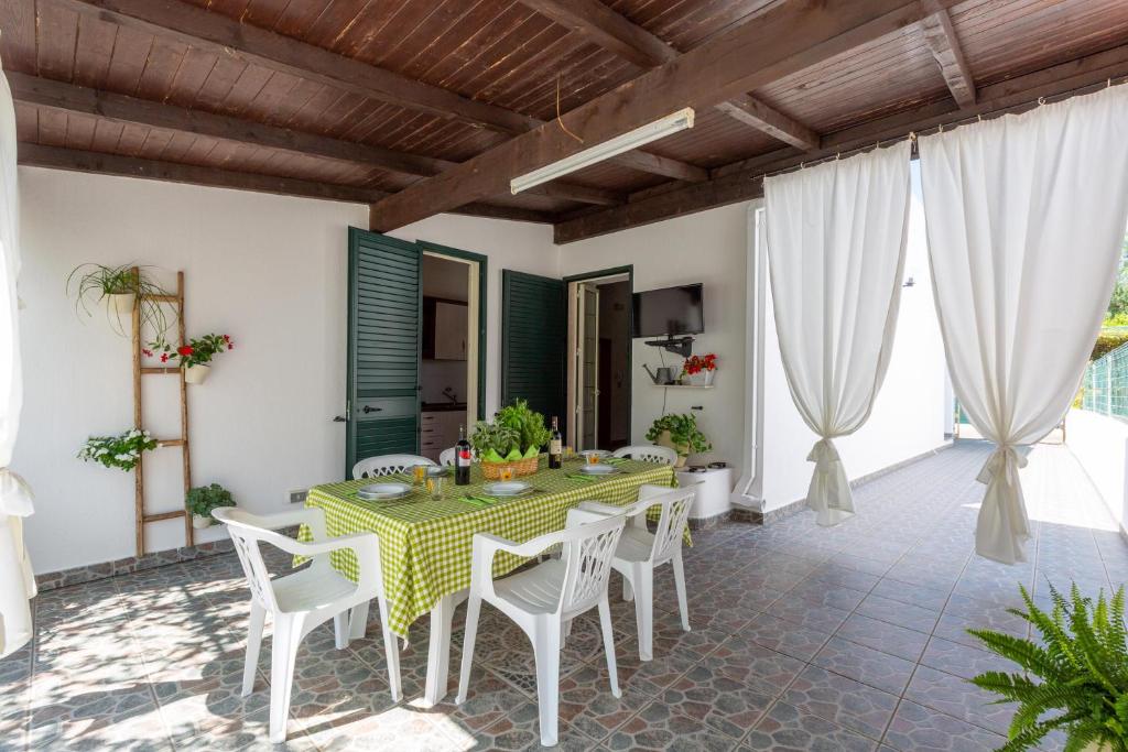 托雷苏达Villa Cielo e Terra by BarbarHouse的一间设有绿色桌子和白色椅子的用餐室