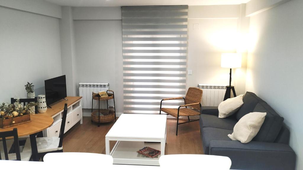 萨拉曼卡VuT BALBOA APARTAMENTO的客厅配有蓝色的沙发和桌子