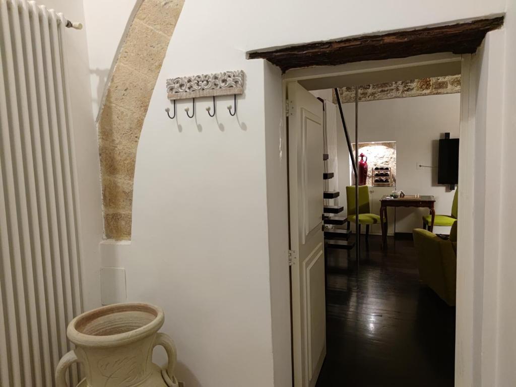 巴里Dimora Arco Basso - Old Town的走廊通往带绿色椅子的用餐室