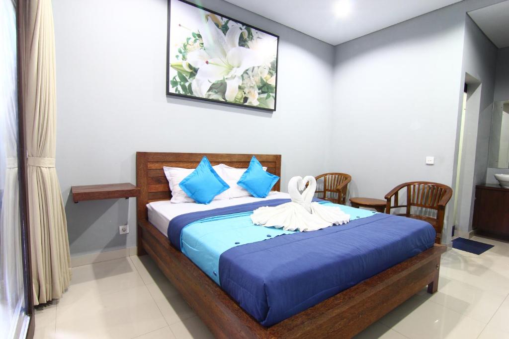 沙努尔Radha Homestay的一间卧室配有一张带蓝色床单和蓝色枕头的床。