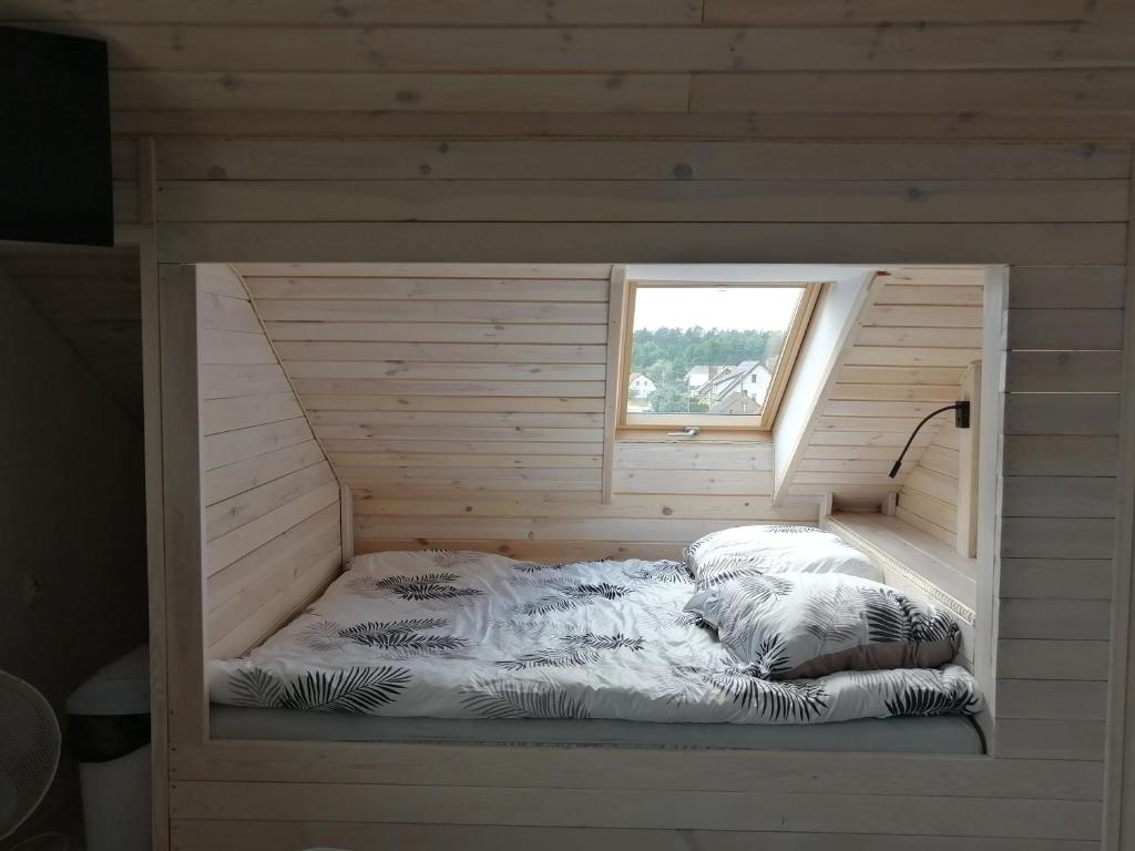 KarsinPAKLADA 3 Pokój typu studio的木制客房的一张床位,设有窗户