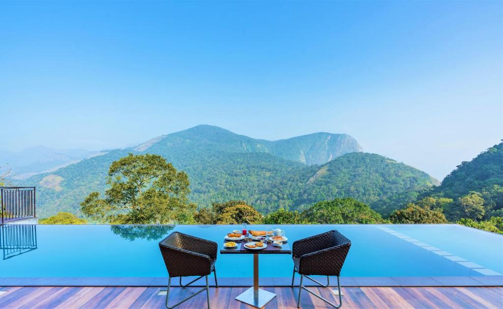 钦纳卡纳Shola Crown Resort - Munnar的山景甲板上的桌椅