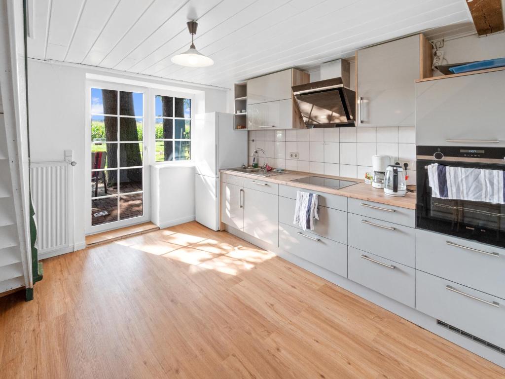 KirchlintelnUnterkunft für Monteure/ Geschäftsreisende bei Familie Bokeloh的厨房铺有木地板,配有白色橱柜。