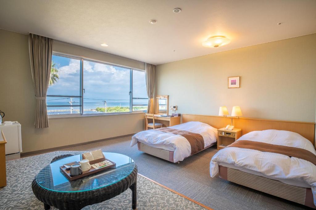 指宿市指宿可兰诺俞酒店的酒店客房设有两张床和大窗户。
