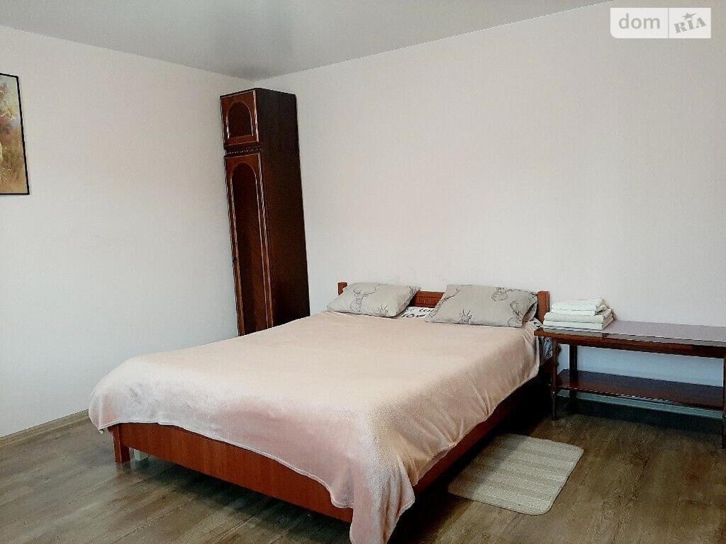 捷尔诺波尔Family and friends apartment的一间卧室配有一张带木制床头板和一张桌子的床。