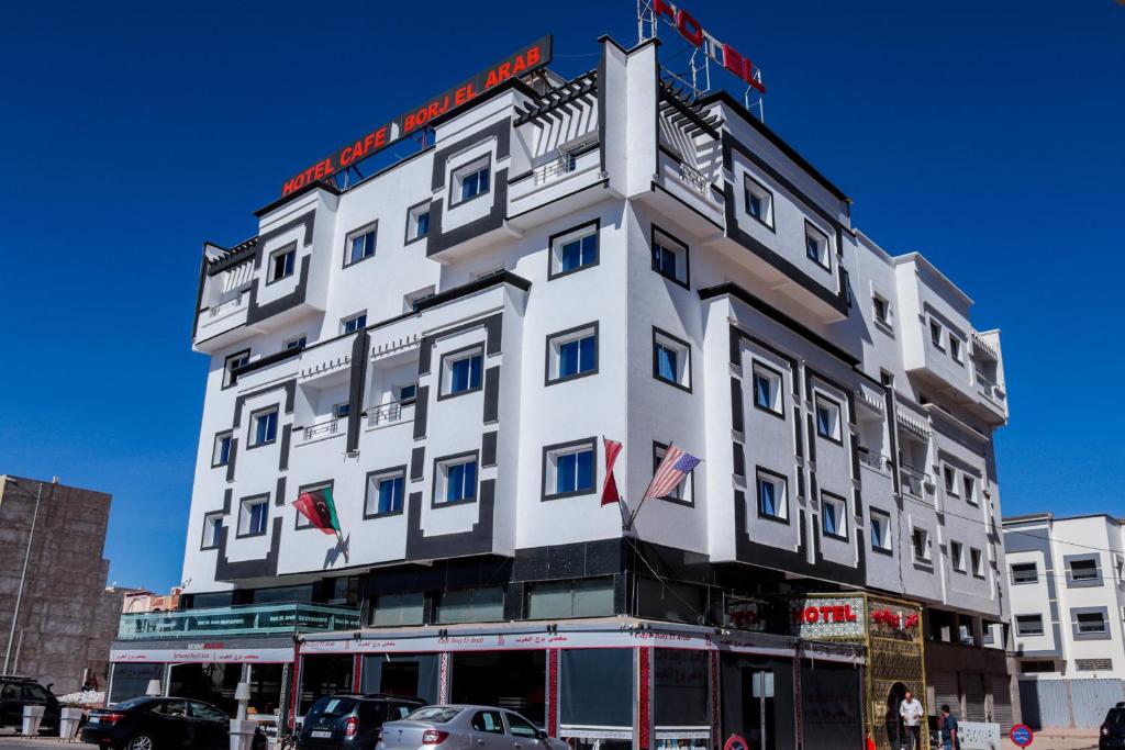 胡里卜盖HOTEL BORJ EL ARAB的一座白色的大建筑,上面有旗帜