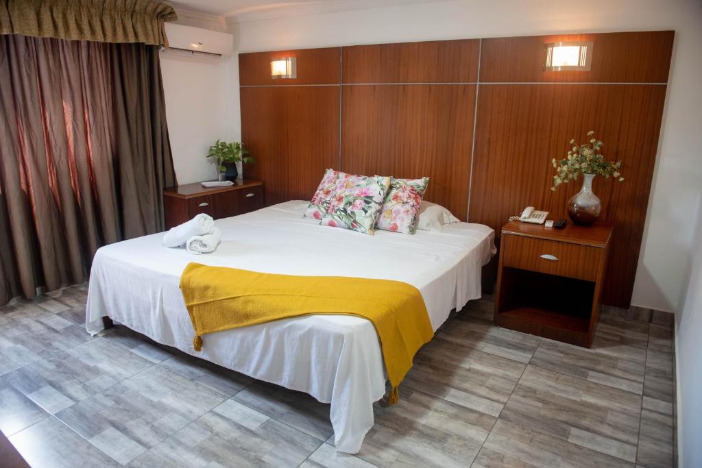 巴拿马城克里斯塔旅馆的酒店客房的床铺上铺有黄色毯子