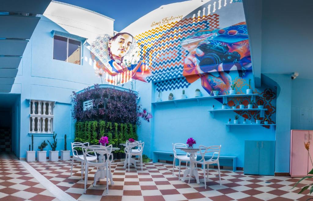 卡塔赫纳San Felicin Hostel的一间拥有蓝色墙壁和桌子的房间,以及壁画