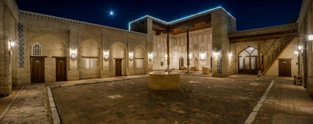 希瓦New Star Boutique hotel - madrasah Muhammad Mahram 1903的一座在晚上设有庭院的大建筑