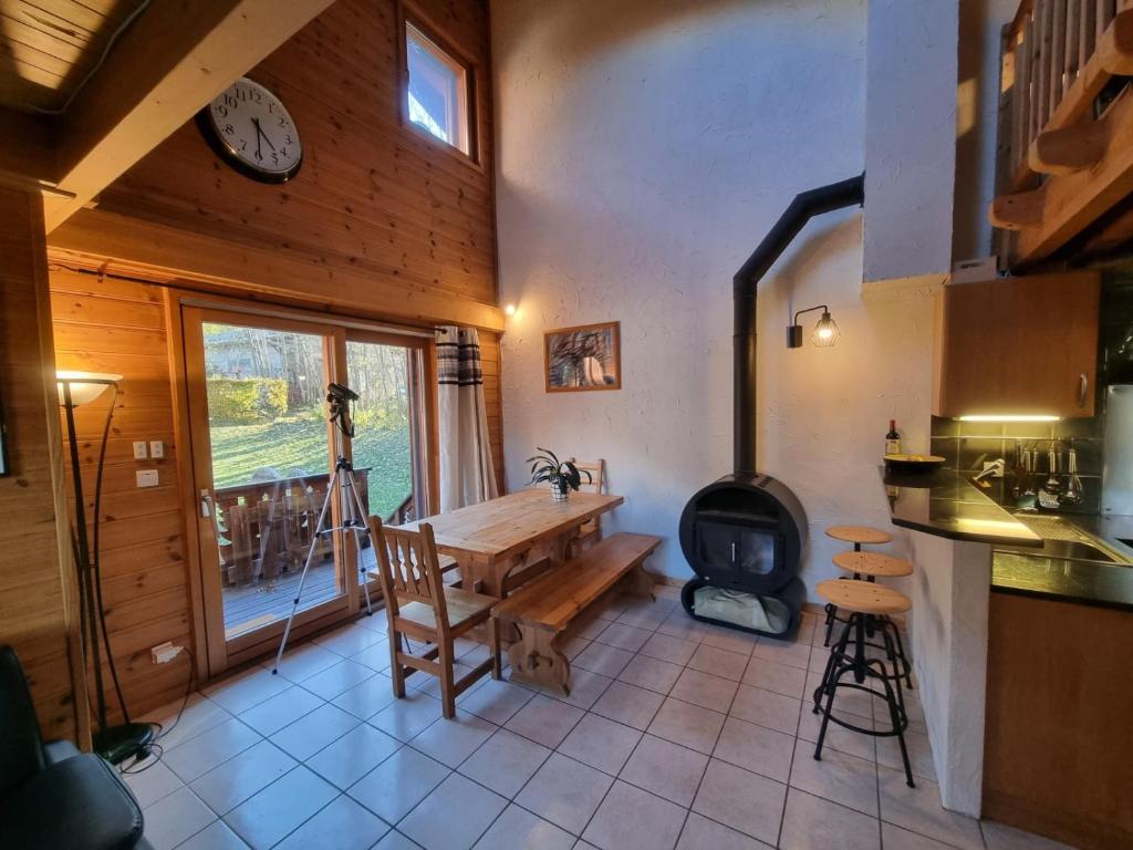 里雾诗Chalet Tontine, 3 bedrooms, sauna, terrace and great views !的厨房配有桌子和燃木炉。