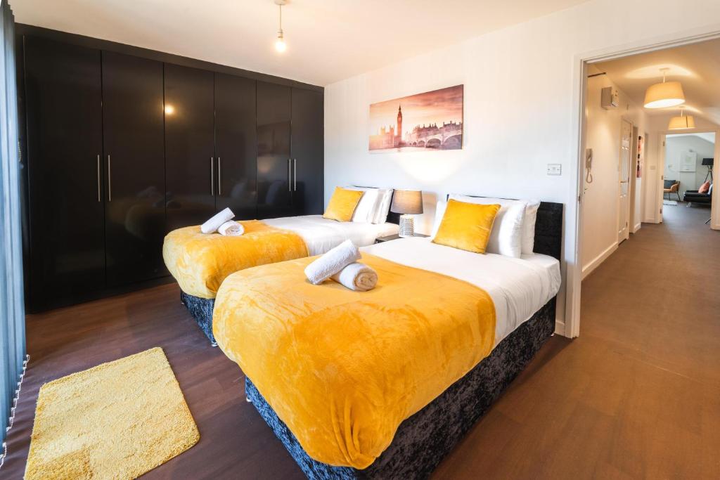 南安普敦Perfect For Business And Leisure- Free Parking的配有黄色床单的酒店客房的两张床