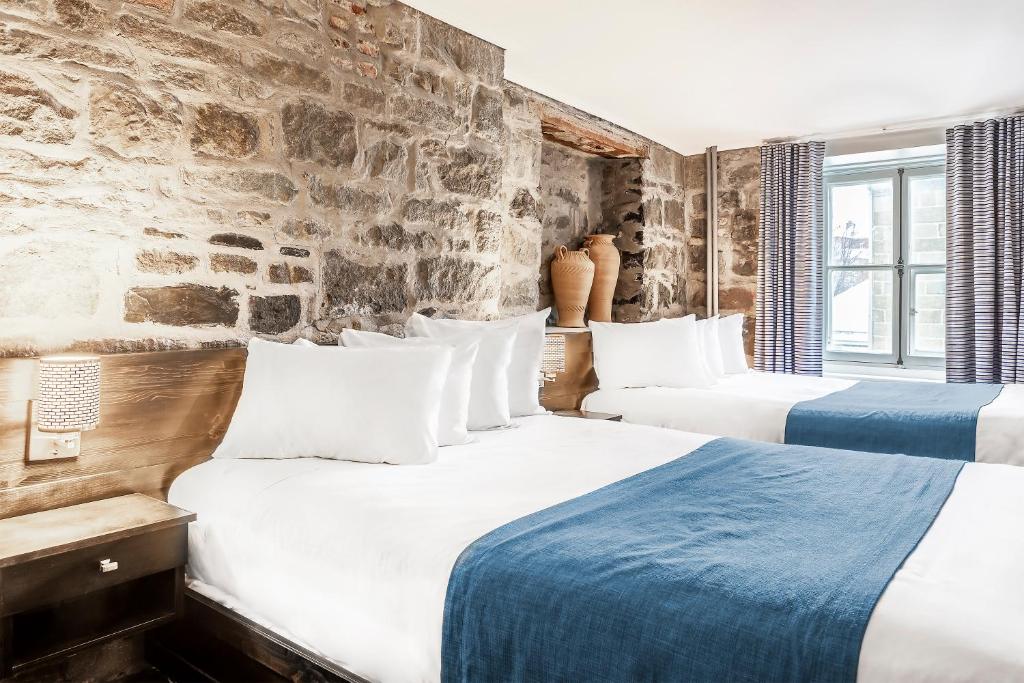 魁北克市路易斯堡酒店的石墙客房的两张床