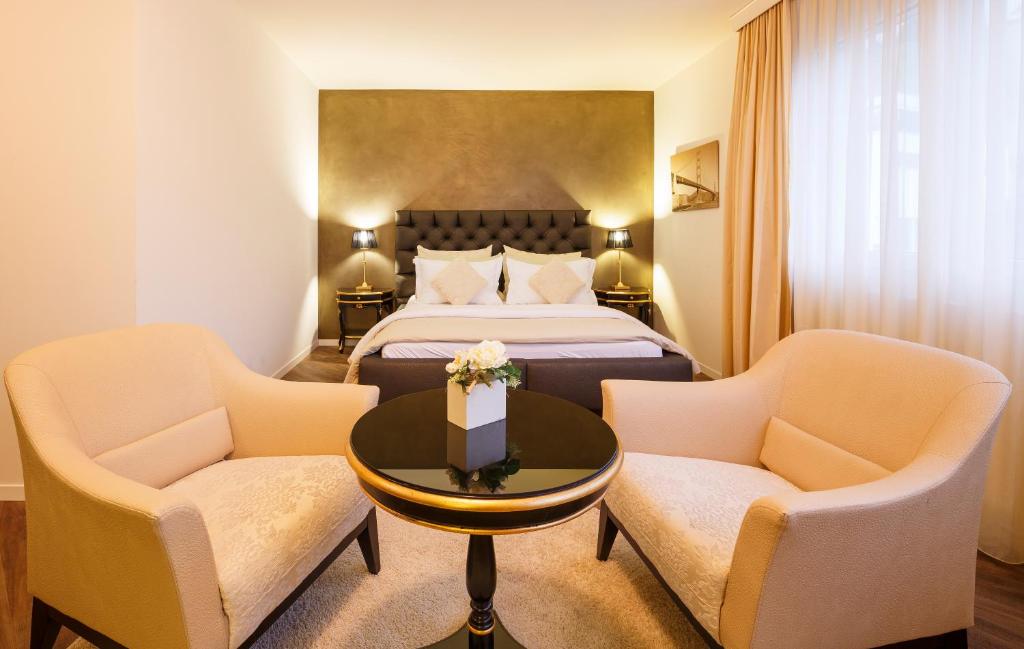弗希斯堡第一商务酒店的酒店客房配有一张床、两把椅子和一张桌子