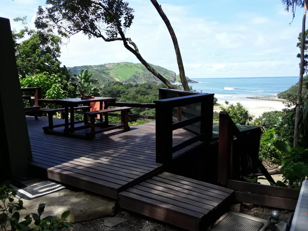 圣约翰港Delicious Monster Accommodation的木甲板设有长椅,享有海景